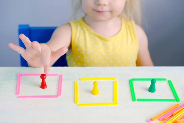 Akıllı küçük çocuk, kız 2 yıl eğitim oyuncağıyla oynar, renkleri öğrenir, çubukları sayarak evler inşa eder, konsept çocukluk, çocuğun erken eğitimi, güzel motor becerilerin gelişimi, düşünme