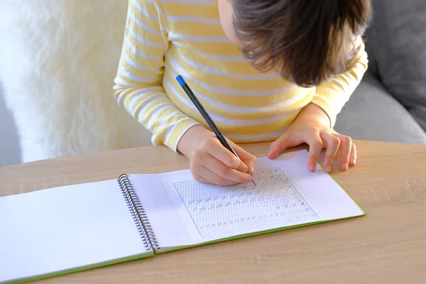 穿着黄色T恤的学童 用铅笔 明亮的背光 教育观念 小学教育 手工操作 发展写作技巧 在笔记本上写字母 — 图库照片