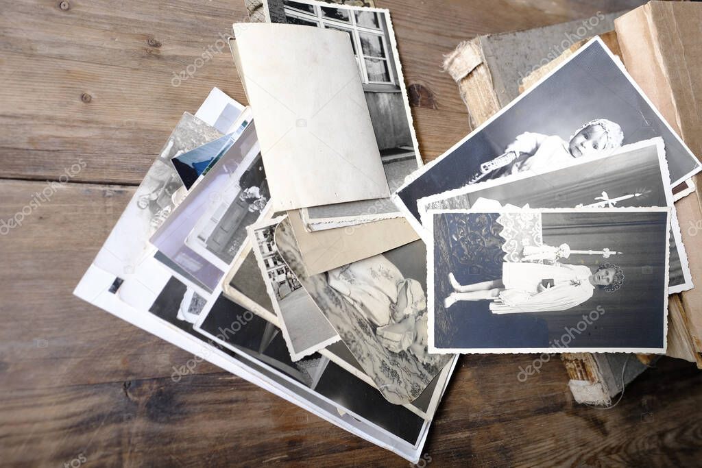 stack of vintage photos, retro photography of 1940-1950 on wooden table, old books, concept of genealogy, memory of ancestors, family tree, genealogy, childhood memories, family archive