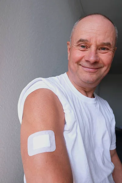 老欧洲人 注射后60岁 身穿衬衫 手上拿着白色石膏 接种疫苗 对人群进行Covid 19病毒疫苗接种的概念 — 图库照片