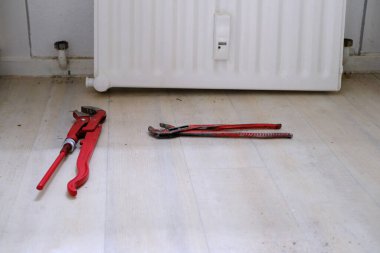 Tesisat, gaz, boru, anahtar ve ayarlanabilir anahtarlar, beyaz ısıtma radyatörü, ısıtma sistemi onarım konsepti için profesyonel tesisat araçları