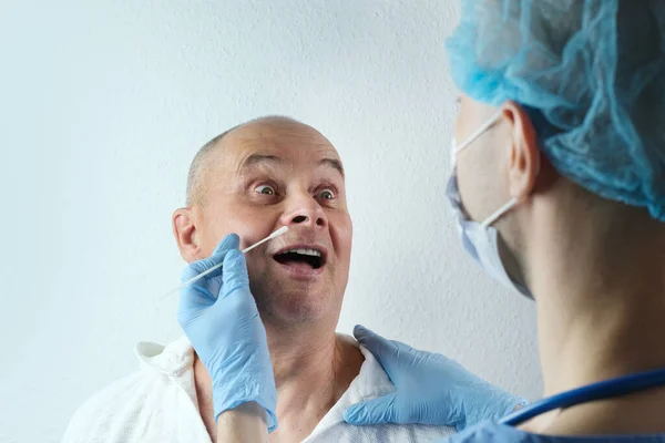 male doctor in gloves takes with swab sample from nose for analysis, rapid nasal test covid-19, detection of viral disease, police investigation, determine paternity, medical examination, coronavirus