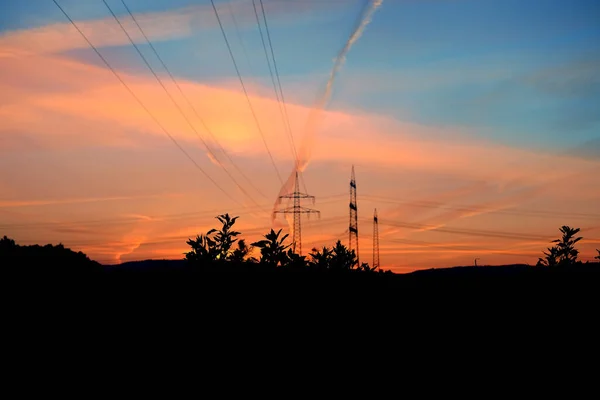 Piękny Krajobraz Niebo Liniami Szlaku Lotniczego Wieże Energetyczne Pole Wieczorem — Zdjęcie stockowe