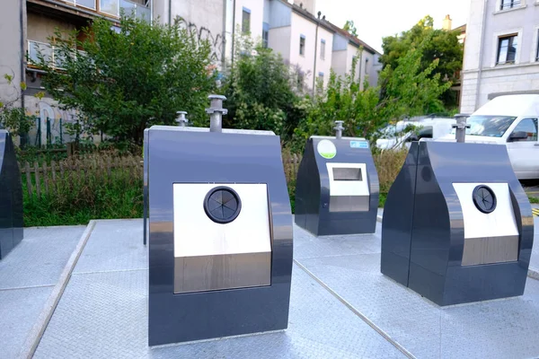 row of metal waste containers for separate sorting at public waste collection site in courtyard of apartment building in Switzerland, concept of cleanliness, recycling, disposal of household waste