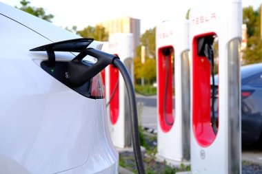 FRANKFURT, Almanya - Eylül 2021: Tesla hafif elektrikli otomobiller şarj istasyonunda pil dolduruyor, alternatif enerji geliştirme kavramı, elektrikli araç üretimi