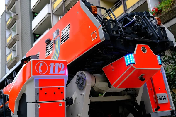 Çok katlı bir binanın avlusuna kırmızı itfaiye aracı geldi. Acil durum 112. Almanya 'da yangın kavramı, yanıp sönen ışıklar.