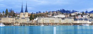 LUCERNE, İsviçre - Aralık 2020: Lucerne Gölü 'nün güzel sonbahar, kış manzarası tarihi mekanlar, Hofkirche Kilisesi, evler, Lucerne Gölü' nün pitoresk sahillerindeki turistik tekneler