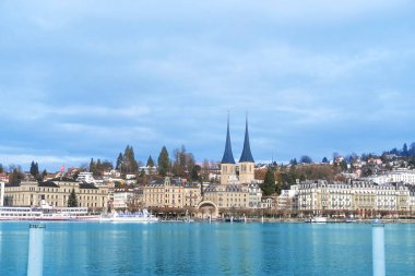 LUCERNE, İsviçre - Aralık 2020: Lucerne Gölü 'nün güzel sonbahar, kış manzarası tarihi mekanlar, Hofkirche Kilisesi, evler, Lucerne Gölü' nün pitoresk sahillerindeki turistik tekneler