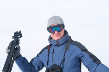 Kameralı yaşlı bir adam, dağ yürüyüşçüsü kış manzarasına hayran, spor konsepti, sağlıklı yaşam tarzı, kış etkinliği, güzel kış doğal manzarası, kışın beyaz ormanda yürüyor.