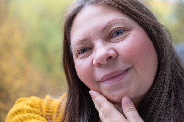 Yakın çekim yüz derisi, kadın yağlı boynunu inceler, sarkık çenesi görünür lekeler, nazikçe dokunan çene hattı, dürüstlük ve dermatoloji, sağlıkla duygusal bağ, yaşla ilgili değişiklikler.