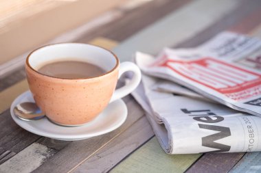 Masada katlanmış gazeteyle sabah kahvesi, haberlerle güne başlamak, barışçıl okuma, sabah rutini yeniden tasarlama, kültür, sanat yavaşlama, ticaret, politika, Frankfurt - 14 Ekim 2025