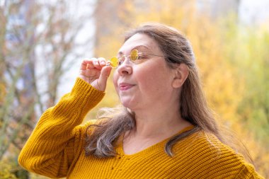 50 yaşında gözlük takan olgun bir kadın, kötü görüş, miyop sorunu, optik muayene, diopter hassasiyeti, gözlüklü bir kadın, doğru lens diopterleri, görüş sağlığı, duygusal portre, yaşlanma