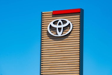 Poyota bayilik tabelası, vitrindeki belirgin logo, şirket bayraklı ofis binası, modern bayilik, kurumsal marka tahtası, Japonya otomotiv teknolojisi, Giessen, Almanya - 28 Haziran 2025