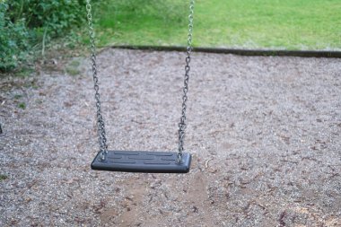 Sessiz parkta boş salıncak, çocuk yok, düşük doğum oranı, sosyal ilgi, terk edilmiş oyun alanı, terk edilmiş salıncak, sakin atmosfer, yalnız sahne, sosyal endişe, doğa.