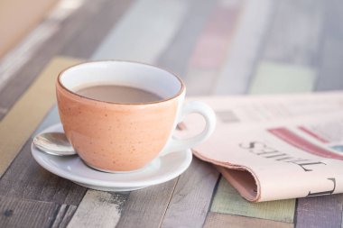 Masada katlanmış gazeteyle sabah kahvesi, haberlerle güne başlayın, barışçıl okuma, sabah rutini yeniden tasarlanmış, basılı medya, gazetecilik, Avrupa kültürü, sanat yavaşlıyor, iş dünyası, siyaset