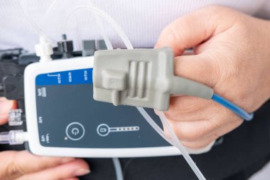 Kadın hasta, kadının karnına takılan 24 saatlik uyku izleme cihazını kullanıyor. Horlama, uyku aşamaları, kalp atış hızı. Sağlık takibi için de parmak ucu nabız oksimetresi kullanılıyor.