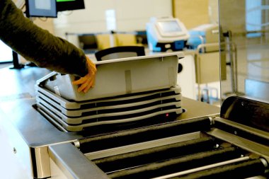 Erkek el, araç gereç, bagaj, çanta için plastik kutuları havaalanı personeli tarafından kontrol edilmek üzere taşımacılar, X-ray makinası havaalanı kontrol noktasına giden kutular, hava taşımacılığı güvenlik gereksinimi için alır.