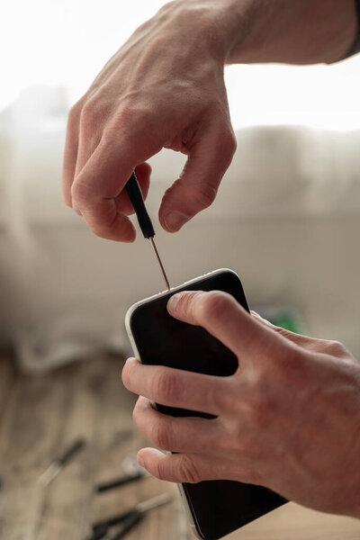 Technician repairing smartphone with precision tools. Close-up of hands fixing mobile phone hardware components, technical support, DIY repair, service center, phone hardware