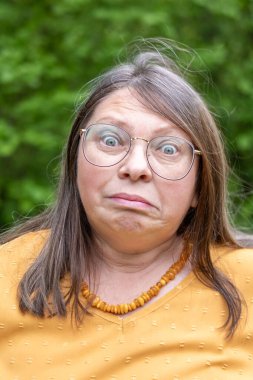 Dramatik bir portre. Şaşırmış bir kadın, şoke olmuş, gözleri açık, şişkin, inançsız ve beklenmedik haberler veren, inançsızlıkla ve şaşkınlıkla donmuş, duygusal bir yüzle bakıyor.