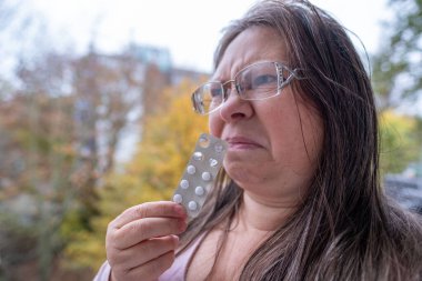 Elinde hap, sağlık, ilaç rutini, düzenli günlük tedavi, sağlık, sağlık, tıbbi bakım, vitamin veya ilaç içeren beyaz su toplayan yetişkin bir kadın.