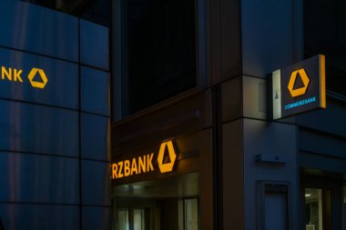 Ticari banka binası gece aydınlandı, parlayan sarı logo, modern mimari, finans bölgesi, şehir sahnesinde kurumsal markalaşma, merkezi Frankfurt, Almanya 'da - 13 Haziran 2025