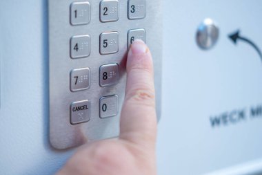 Dijital tuş takımı kasasında veya güvenlik kutusunda gizli erişim şifresi, doğrulama, kimlik doğrulama veya kişisel eşyaların korunması için insan parmağının yakın plan numarası