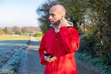 Programcı, kahverengi kablo örgü süveter giyen genç adam bilgisayarda çalışıyor, fincan çay sunan kadın, modern ev ofis ortamı üretkenliği ve sakin ve destekleyici ilişkiyi destekliyor. 