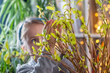 Bahçede çiçek açan beyaz çiçekleri keşfeden üç çocuk hasır şapkalı kız meraka erişiyor, ilkbahar doğa keşfi anı çiçek açan ağaçların yakınındaki polen hassasiyeti, mevsimsel alerji 