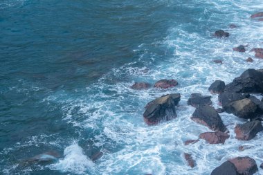 Madeira 'daki siyah volkanik kumsal ve mavi su okyanusu, Portekiz kıyıları, Atlantik dalgaları güneşte parlıyor, sıcak Körfez akıntısı su akıntıları, seyahat rüyası, huzurlu enerji, deniz yaşamı