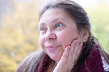 Yaşlı mutlu kadın güneşli terasta hasır sandalyelerde sallanıyor, okyanus manzarası ve sohbetin tadını çıkarıyor, ve sakin sahil kenarında yaşıyor, iç huzur ve güven, ve zarif bir şekilde yaşlanan güzellik