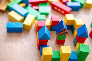 Küçük bir anaokulu kızı evde ahşap bloklar bina kulesi, erken eğitim, iyi motor beceriler, çocukluk sevinci, simülasyon aktivitesi çocukları ile oynuyor.