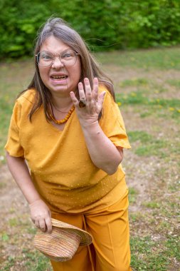 Yetişkin, beyaz bir kadın, 50 yıl boyunca el ele tutuşmuş, yüzü yaralı kadın yüzünü kapatmış, kulaklarında çınlama, kulak çınlaması, orta kulak iltihabı, akustik travma...