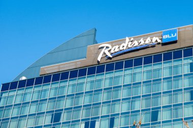 Mavi gökyüzüne karşı belirgin ikonik DB logosu olan modern bina, Deutsche Bahn şirketinin taşımacılık ve cam cephe bağlantısına karşı bağlantı, Frankfurt - 19 Ocak 2025