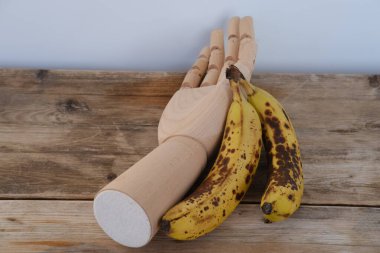 Sağlıklı kahvaltı için tahta kesme tahtasında olgun muzları dilimlemek taze doğal malzemeler, cam süt ve fındık kasesi köy masasında, pişirme süreci ve besleyici sabah yemeği konsepti.