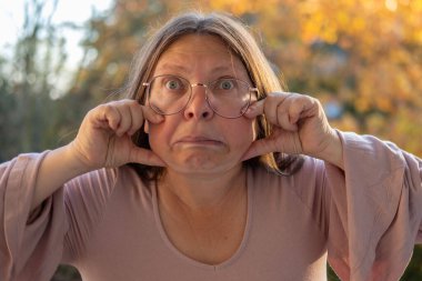 Hayal kırıklığına uğramış 50 yaşında beyaz bir kadın sunuyor, euro banknotlarını sayıyor, elinde az para, nakit ödemeler, tasarruflar, döviz kurları, finansal özgürlükler