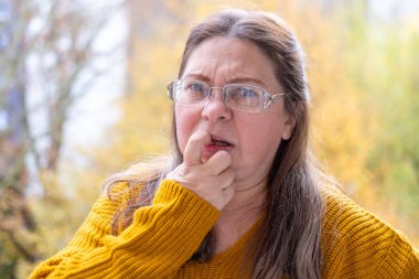 Hayal kırıklığına uğramış 50 yaşında beyaz bir kadın sunuyor, euro banknotlarını sayıyor, elinde az para, nakit ödemeler, tasarruflar, döviz kurları, finansal özgürlükler