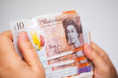 Yakın plan kadın elleri İngiliz banknotları, kağıt para, İngiliz GBP banknotları, Para İdaresi Doğruluk, maaş, fon ödemeleri, finansal özgürlük, tatil için tasarruf