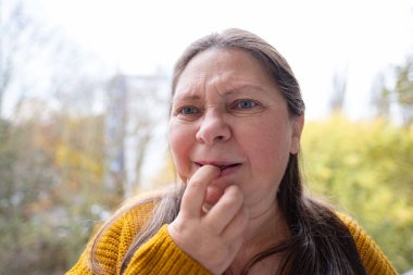 Stresli kadın tırnak yer, gergin ifade kadın endişe ve üzüntüyü yansıtır, doğal ortamda derin endişe, aşırı stres ve yakın plan, samimi doğa portresi.