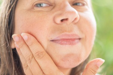 Olgun bir kadın ruj sürüyor, doğal makyaj, son sınıf tarzı, eko kozmetik ürünü, ruj kullanan son sınıf öğrencisi, güzellik bakımı, sağlıklı otantik cilt portresi.