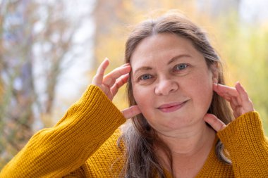 Olgun bir kadın ruj sürüyor, doğal makyaj, son sınıf tarzı, eko kozmetik ürünü, ruj kullanan son sınıf öğrencisi, güzellik bakımı, sağlıklı otantik cilt portresi.