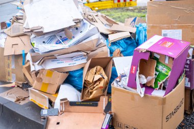 Çöpe atılmış karton kutular, kentsel sokak kaldırımlarına ambalaj atığı, gıda konteynırları ve markalı kutular dahil olmak üzere karışık ticari atıklar, Hannover, Almanya 'da tüketici kültürü - 17 Şubat 2026