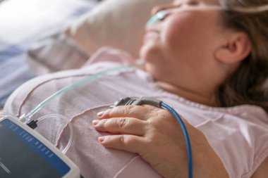 Klinik uyku çalışma sensörleri olan hasta, burun kanülü ve nabız oksimetresiyle yatan kadın, tıbbi izleme apne cihazı, tarama ve tedavi kronik uyku eksikliği