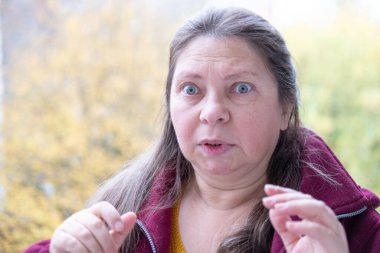 Şokta olan orta yaşlı bir kadın, ağzı açık ve gözleri açık, saf duygu sürprizi ve inançsız beklenmedik haberleri yakalıyor, olgun bir kadın şaşkınlık ve şokla tepki veriyor. Duygusal Portre