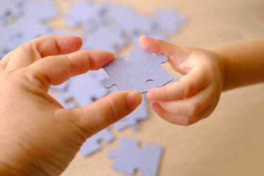 Küçük çocuk ve anne birlikte oynuyorlar, ebeveyn kızına bulmacaları birleştirmeyi öğretiyor, bulmaca çözerek bilişsel gelişim, öğrenme sürecinde ebeveynlik.