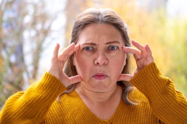 Yakın plan olgun kadın 50 yaşında, insan boynu, yerçekimsel ptosis, çift sarkık çene, Yaşlanma ve Yüz Görünümü, yaşla ilgili deri değişiklikleri, kozmetik yaşlanmayı önleme prosedürleri, cilt sıkılaştırma