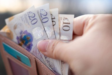 Deri çanta, erken para, mali refah, nakit tasarrufu, başarılı alışveriş ve tüketicilik, mali bağımsızlık ve kişisel zenginlik yığını çıkaran kadınların elleri