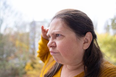 Göğüs ağrısı çeken orta yaşlı bir kadın, el kalbe baskı yapıyor. Sağlık sorunları, kalp krizi ve sıkıntı, sağlık riski, kalp yetmezliği ve acil durum kavramı