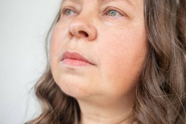 Göğüs ağrısı çeken orta yaşlı bir kadın, el kalbe baskı yapıyor. Sağlık sorunları, kalp krizi ve sıkıntı, sağlık riski, kalp yetmezliği ve acil durum kavramı