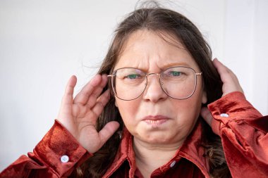 Göğüs ağrısı çeken orta yaşlı bir kadın, el kalbe baskı yapıyor. Sağlık sorunları, kalp krizi ve sıkıntı, sağlık riski, kalp yetmezliği ve acil durum kavramı