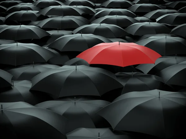 Red umbrella over many black umbrellas — Stock Photo, Image